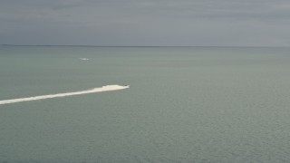 AX0021_156E - 5K aerial stock footage track a sport boat racing on Biscayne Bay, Florida