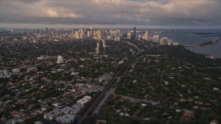 AX0022_022 - 5K aerial stock footage tilt from Coconut Grove suburbs to reveal Downtown Miami at sunset, Florida