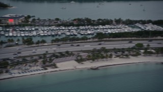 AX0022_075 - 5K aerial stock footage pan across light traffic on the Rickenbacker Causeway at sunset, Florida