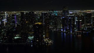 5K aerial stock footage of flying by high-rises on the shore of Brickell Key at night and reveal river in Downtown Miami, Florida Aerial Stock Footage | AX0023_057E