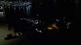 AX0023_064 - 5K aerial stock footage approach Pilot Boat Docks at the end of the Port of Miami at night, Florida