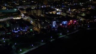 5K aerial stock footage of hotels and cafes with bright lights at night in South Beach, Florida Aerial Stock Footage | AX0023_071E