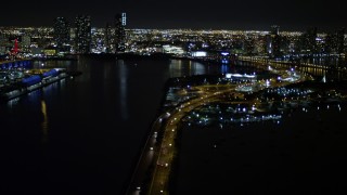 5K aerial stock footage tilt from the MacArthur Causeway to reveal skyscrapers in Downtown Miami at night in Florida Aerial Stock Footage | AX0023_135