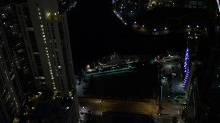 5K aerial stock footage flyby yacht on the river and Downtown Miami skyscrapers at night, Florida Aerial Stock Footage | AX0023_170E