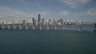 AX0024_052E - 5K aerial stock footage tilt from Biscayne Bay to reveal Rickenbacker Causeway, Downtown Miami, Florida