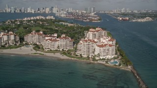 AX0024_099 - 5K aerial stock footage of flying by condominium complexes, Fisher Island, Florida