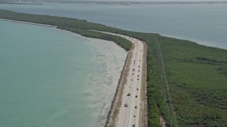 5K aerial stock footage video of traffic on Overseas Highway, reveal coastal mangroves, Key Largo, Florida Aerial Stock Footage | AX0025_048