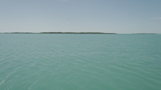 AX0025_075 - 5K aerial stock footage of flying low over water, approaching mangroves on shore, Key Largo, Florida