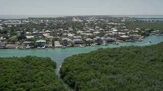 5K aerial stock footage of flying low over mangroves toward Tavernier Creek homes, Tavernier, Florida Aerial Stock Footage | AX0025_090