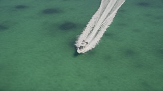 AX0025_094 - 5K aerial stock footage of orbiting a fishing boat speeding across water, Tavernier, Florida