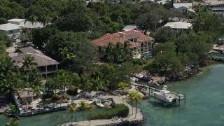 5K aerial stock footage of approaching and flying by waterfront mansions on the shore, Tavernier, Florida Aerial Stock Footage | AX0025_100E