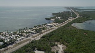 5K aerial stock footage of following Overseas Highway, passing resorts and marinas, Islamorada, Florida Aerial Stock Footage | AX0025_106E