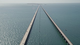 AX0026_024E - 5K aerial stock footage of following light traffic traveling on Seven Mile Bridge, Florida