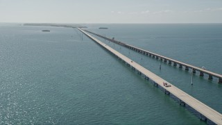 AX0026_027E - 5K aerial stock footage of crossing over the bridge and following light traffic, Seven Mile Bridge, Florida