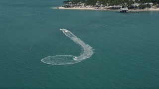 AX0026_091 - 5K aerial stock footage video of a jet skier near the shore of Key West, Florida