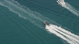 5K aerial stock footage of tracking speedboat racing across water by Key West, Florida Aerial Stock Footage | AX0026_101