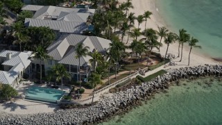 AX0026_103 - 5K aerial stock footage of orbiting homes on the shore of Sunset Key by Key West, Florida