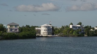 AX0027_063E - 5K aerial stock footage of flying by homes on the shore, Cudjoe Key, Florida