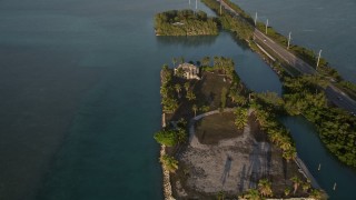 AX0028_022 - 5K aerial stock footage of approaching a home and tilt down to bird's eye view of it at sunset, Craig Key, Florida