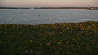 5K aerial stock footage of flying over mangroves, approaching sailboats and fishing boat at sunset, Key Largo, Florida Aerial Stock Footage | AX0028_033