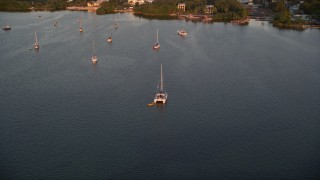 5K aerial stock footage of approaching a catamaran, sailboats at sunset, Key Largo, Florida Aerial Stock Footage | AX0028_034