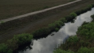 5K aerial stock footage fly over marshland, reveal river, country road, Florida Everglades, Florida Aerial Stock Footage | AX0030_099