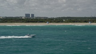 5K aerial stock footage of a speedboat cruising near the shore, Bal Harbour, Florida Aerial Stock Footage | AX0031_072