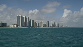 AX0031_073E - 5K aerial stock footage fly over Atlantic Ocean, reveal Trump Towers, Sunny Isles Beach, Florida