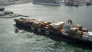 5K aerial stock footage approach and orbit tugboats turning cargo ship, Port Everglades, Fort Lauderdale, Florida Aerial Stock Footage | AX0031_103E