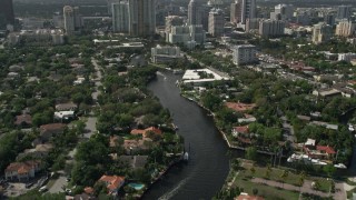 5K aerial stock footage of following New River past mansions, revealing Downtown Fort Lauderdale, Florida Aerial Stock Footage | AX0031_113