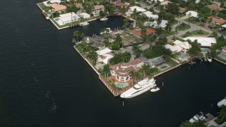 5K aerial stock footage of approaching mansion by canal and a yacht, tilt down, Fort Lauderdale, Florida Aerial Stock Footage | AX0031_141