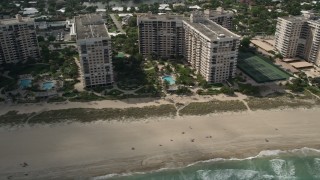 5K aerial stock footage of flying by apartment buildings, sunbathers, Lauderdale by the Sea, Florida Aerial Stock Footage | AX0031_147