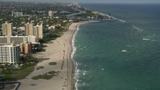 AX0032_006 - 5K aerial stock footage approach Hillsboro Inlet Light, tilt down to sunbathers, Pompano Beach, Florida