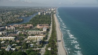 AX0032_028E - 5K aerial stock footage of following the coast, orbit condo complex on North Ocean Boulevard, Boca Raton, Florida