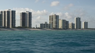 5K aerial stock footage of passing by coastal condominium complexes, Riviera Beach, Florida Aerial Stock Footage | AX0032_118