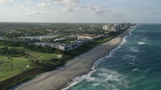 5K aerial stock footage of flying along the coast by apartment buildings, Juno Beach, Florida Aerial Stock Footage | AX0032_127