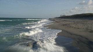 AX0032_148 - 5K aerial stock footage of flying low over waves rolling onto the beach, Hobe Sound, Florida