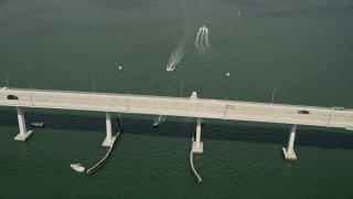 5K aerial stock footage of following speedboats near a bridge in the Indian River, Stuart, Florida Aerial Stock Footage | AX0033_007