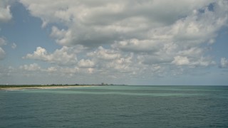 AX0033_031 - 5K aerial stock footage of flying low over the ocean toward a beach, Fort Pierce, Florida