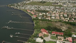 AX0033_070 - 5K aerial stock footage tilt up from riverside residential neighborhood revealing a mobile park, Melbourne Beach