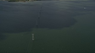 AX0033_072 - 5K aerial stock footage of orbiting power lines crossing a river, Melbourne Beach, Florida