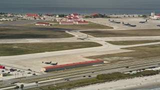 AX0034_003 - 5K aerial stock footage of flying by a military plane on the runway, Patrick Air Force Base, Florida