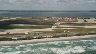 AX0034_004 - 5K aerial stock footage fly by a turboprop plane on the runway, Patrick Air Force Base, Florida