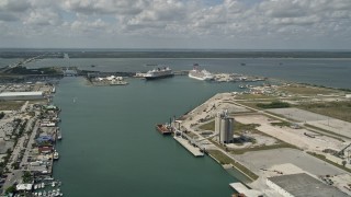 AX0034_016 - 5K aerial stock footage of tilting and revealing a Disney and Carnival cruise ship, Port Canaveral, Florida