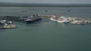 AX0034_017 - 5K aerial stock footage of approaching Carnival and Disney Cruise Ships, Port Canaveral, Florida