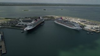 AX0034_018 - 5K aerial stock footage of approaching a Disney and Carnival Cruise Ship, Port Canaveral, Florida