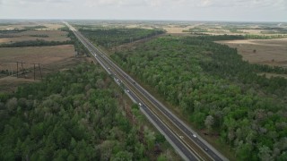 5K aerial stock footage of following an Expressway through trees and a rural area, La Belle, Florida Aerial Stock Footage | AX0034_064E