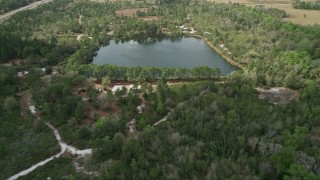 5K aerial stock footage of approaching a small lake and campground among trees, La Belle, Florida Aerial Stock Footage | AX0034_066