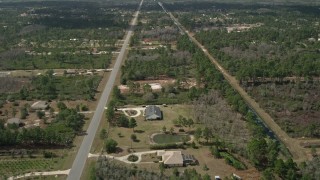 AX0034_070E - 5K aerial stock footage of flying over homes and trees in Wedgefield, Florida