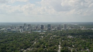 5K aerial stock footage fly over trees toward Downtown Orlando, Florida Aerial Stock Footage | AX0034_083E